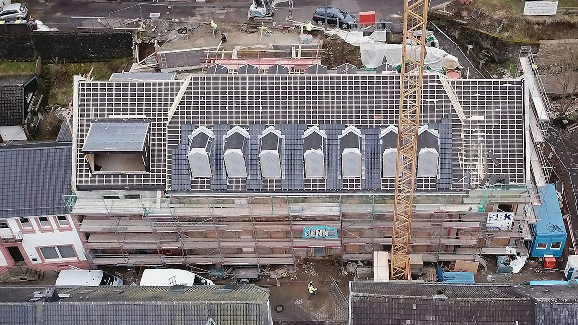 Das Luftbild zeigt das historische Gebäude an der Blankenheimer Ahrstraße. Das Haus ist eingerüstet, das Dach ist abgedeckt.