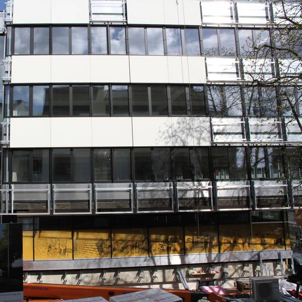 Die Fassade eines Verwaltungsgebäudes, an dem noch einige Fassadenplatten fehlen.