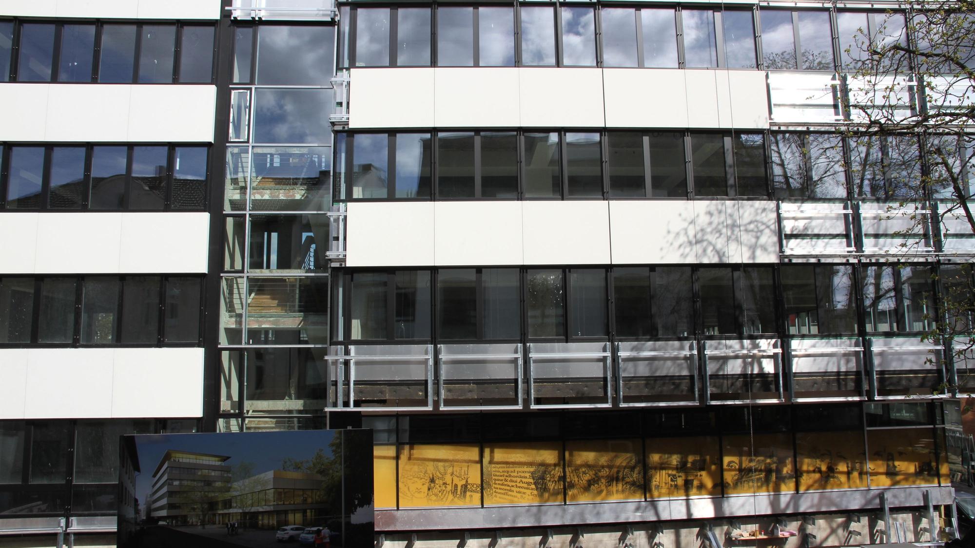 Die Fassade eines Verwaltungsgebäudes, an dem noch einige Fassadenplatten fehlen.