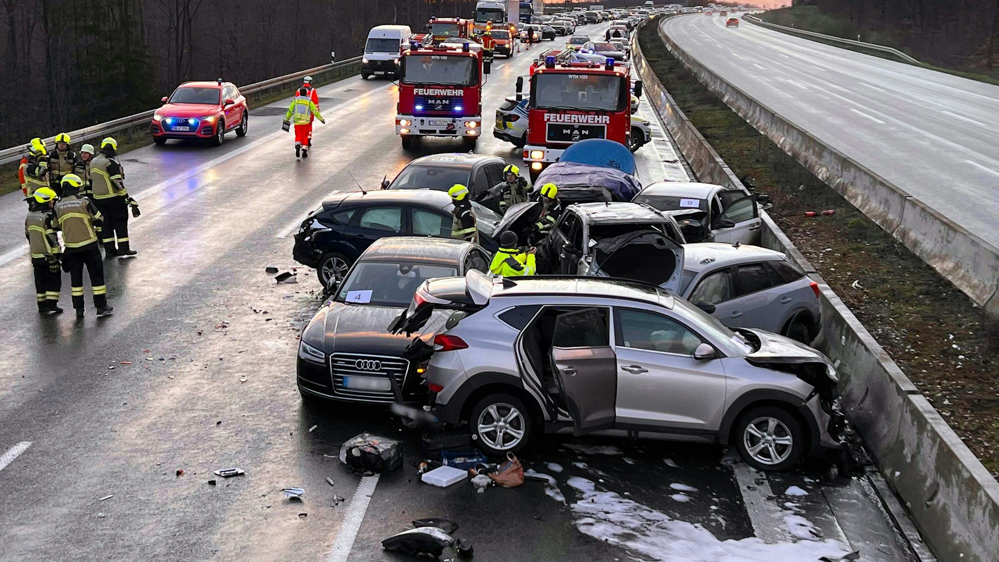 Mehrere Fahrzeuge stehen nach einer Massenkarambolage an der Unfallstelle.