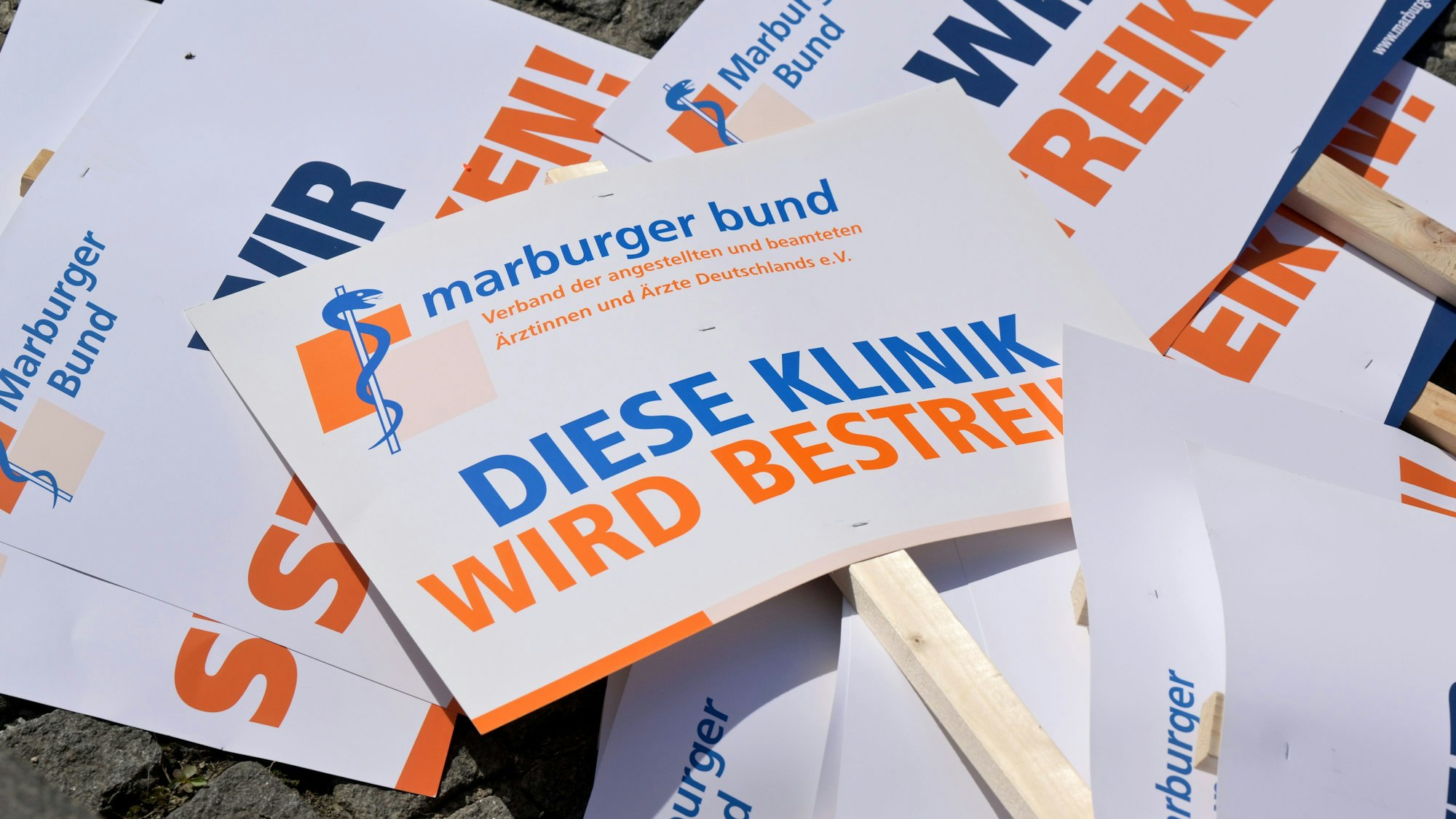 Plakate von Medizinern von bayerischen Unikliniken für einen Protestmarsch durch die Innenstadt liegen auf dem Boden.