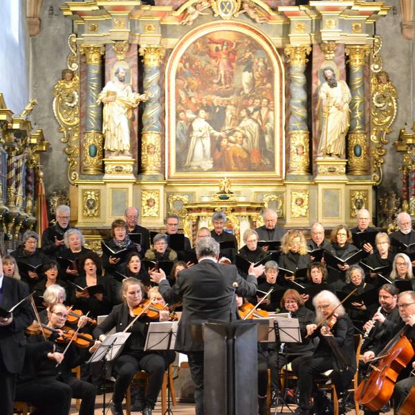 Orchester und Chor musizieren in der Basilika, im Hintergrund der Altar.