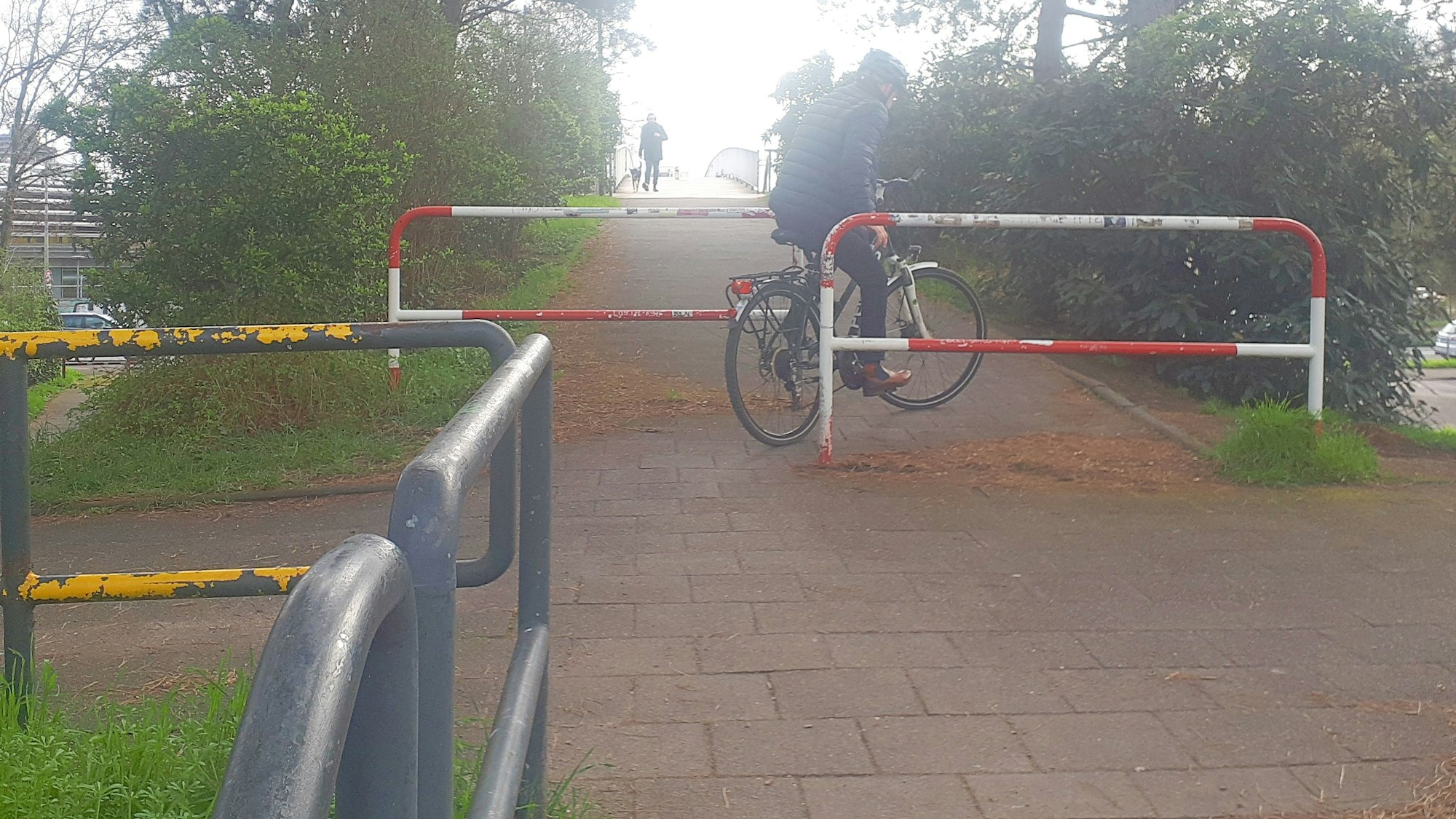Um auf die Lentpark-Brücke zu fahren, müssen Radfahrer eine steile Auffahrtsrampe und ein Doppel-Umlaufgitter passieren. Dieser Radler schafft es so gerade.