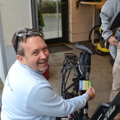 Ein Mann bereitet die Codierung am Fahrrad vor. Dessen Besitzer schaut ihm dabei zu.