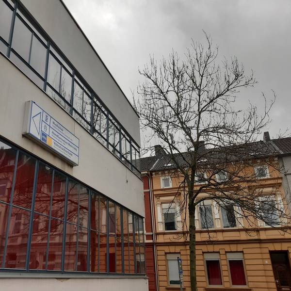 Eine Häuserzeile spiegelt sich in der Fensterfront eines weiteren Hauses