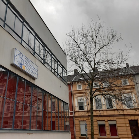Eine Häuserzeile spiegelt sich in der Fensterfront eines weiteren Hauses