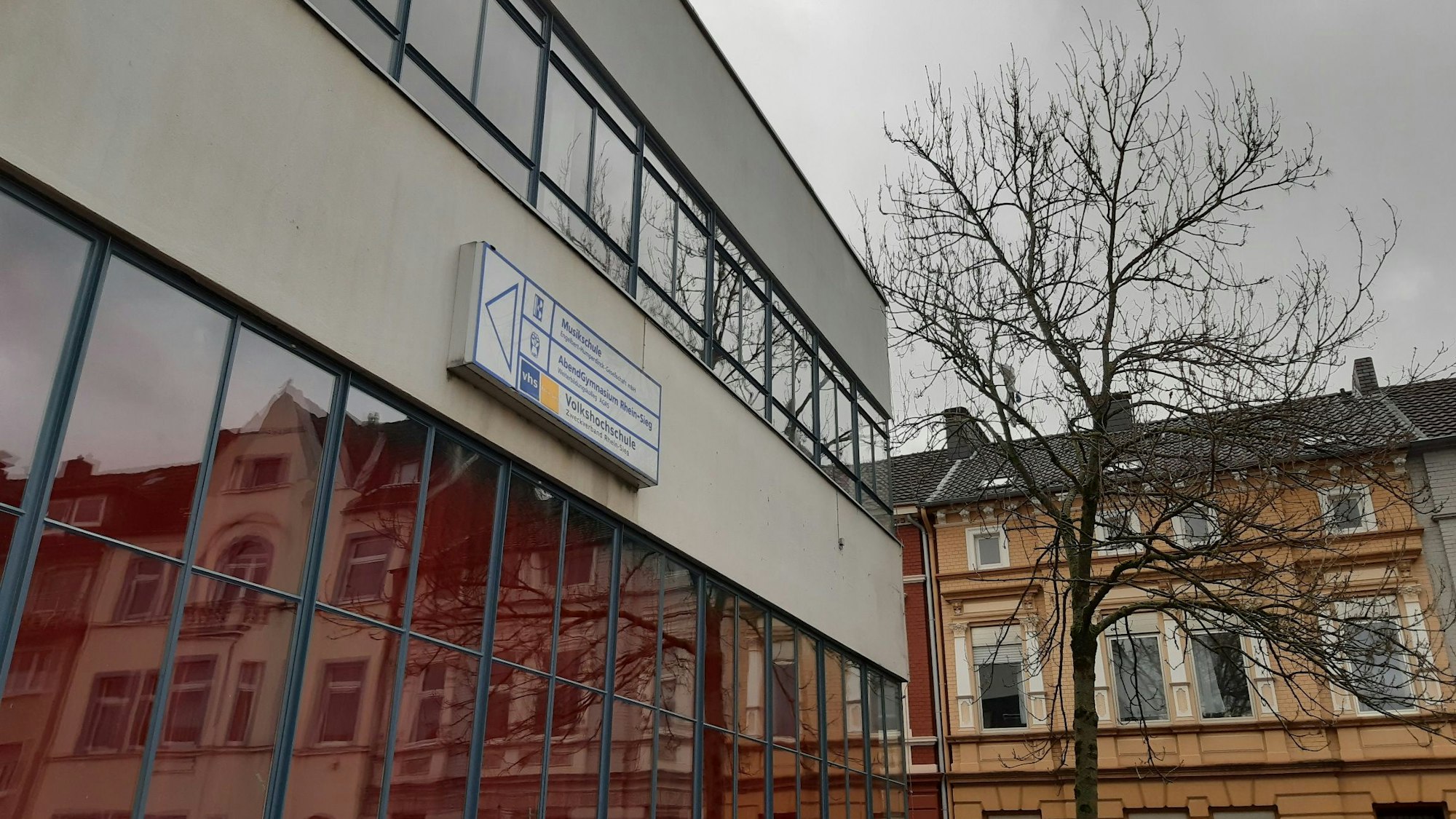 Eine Häuserzeile spiegelt sich in der Fensterfront eines weiteren Hauses