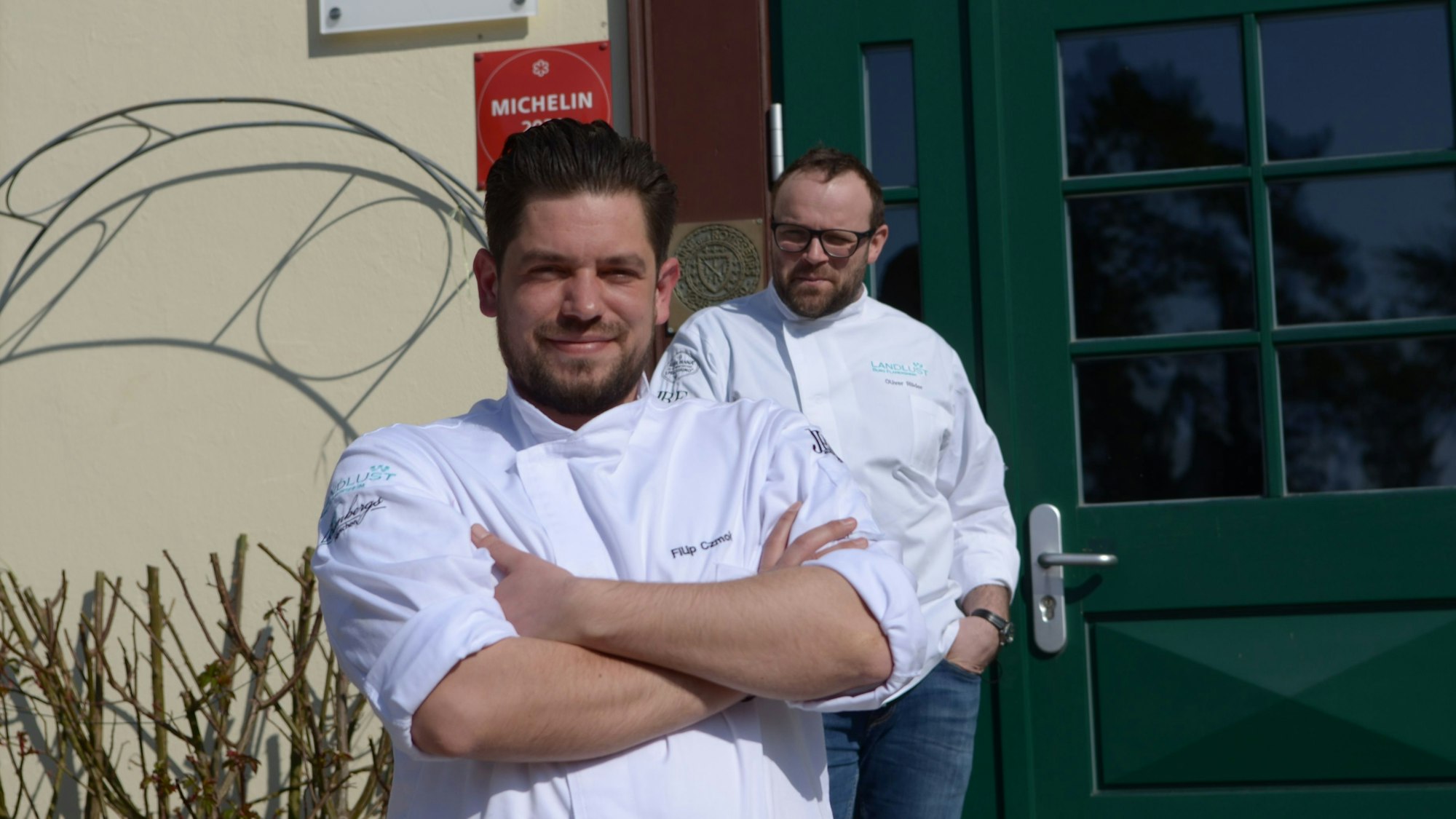 Filip Czmok und Oliver Röder stehen vor dem Eingang des Restaurants.