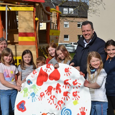 Die Kinder zeigen eine Holzscheibe, die sich künstlerisch gestaltet haben.