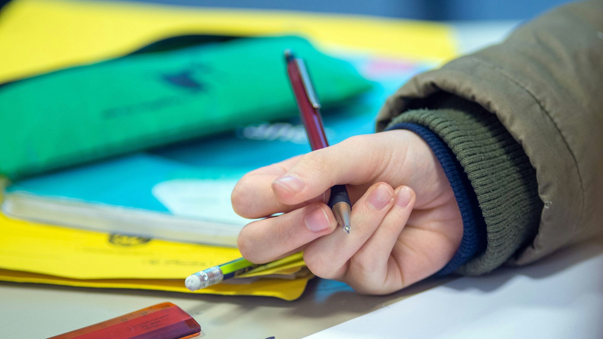 Ein Schüler schreibt im Unterricht.