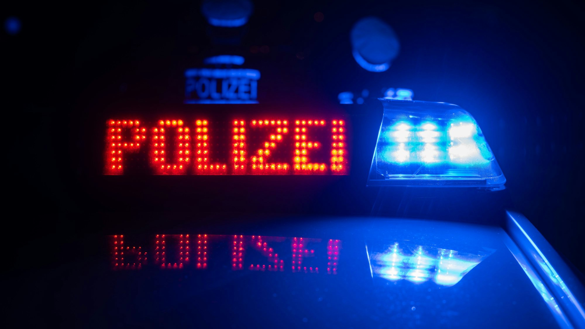 ILLUSTRATION - 30.11.2023, Baden-Württemberg, Stuttgart: Zwei Polizisten stehen im Rahmen eines Fototermins vor einem Polizeifahrzeug (gestellte Szene). (zu dpa: «19-Jähriger soll Eltern und Bruder getötet haben») Foto: Marijan Murat/dpa +++ dpa-Bildfunk +++