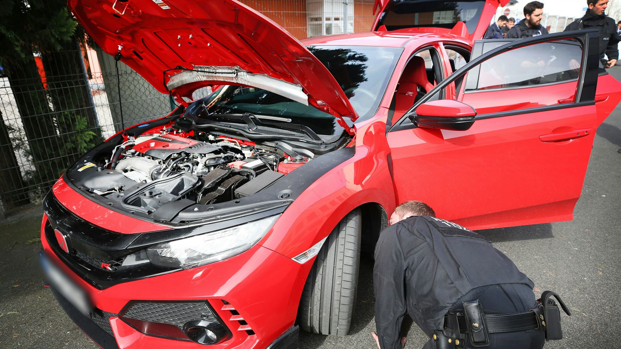 Polizisten kontrollieren ein getuntes Auto.