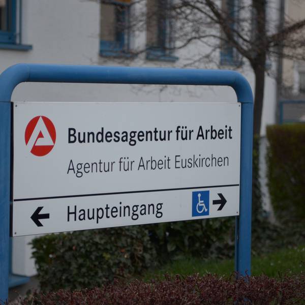 Ein Schild in einem blauen Rahmen weist den Weg zum Gebäude der Bundesagentur für Arbeit an der Thoméstraße in Euskirchen.