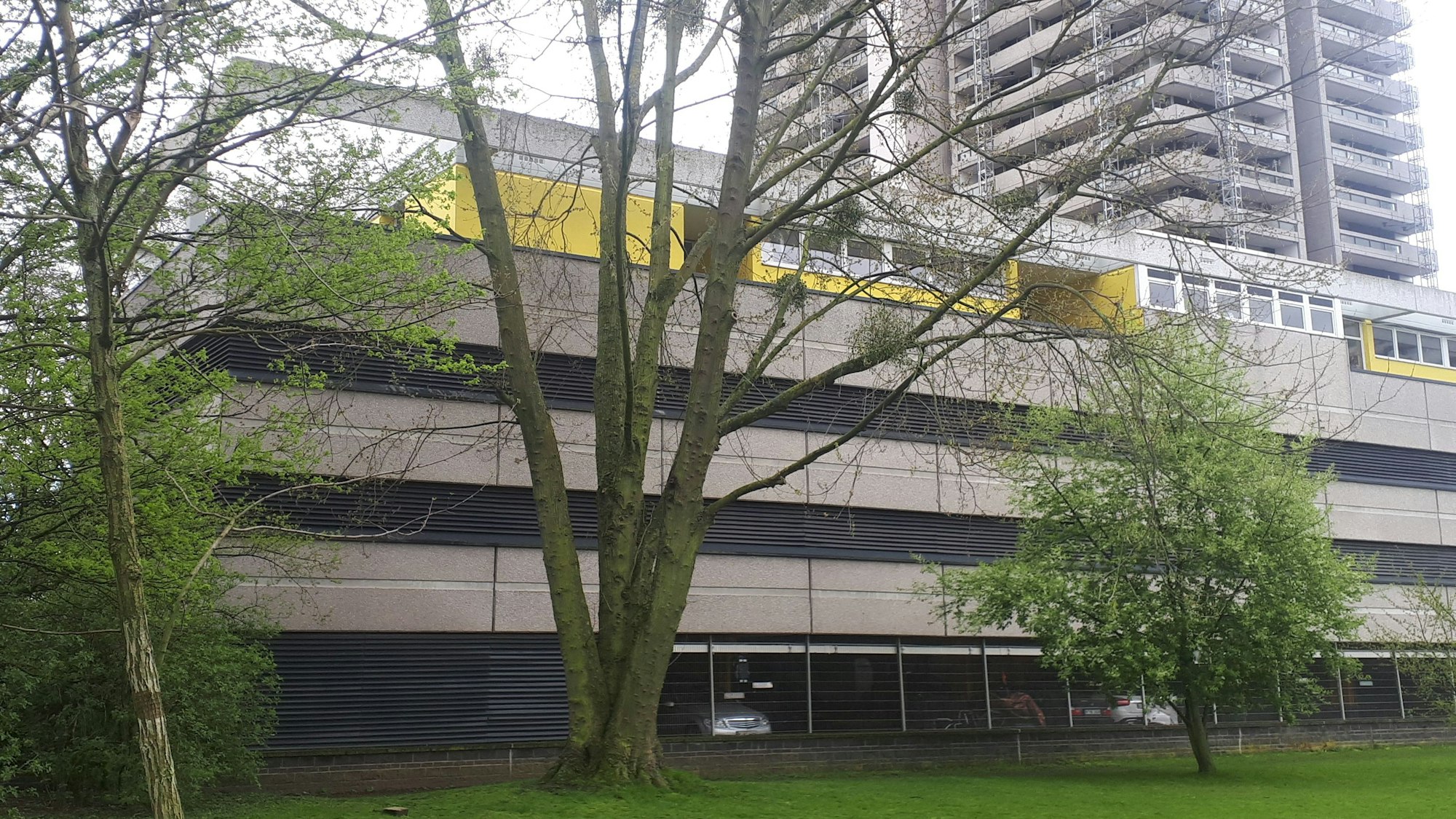 Die Kita (gelbes Gebäude) liegt auf den Parkdecks des Colonia-Hauses. Wegen der laufenden Balkonsanierung am Hochhaus hat die Kita bis auf weiteres geschlossen, die Gruppen sind in zwei andere Kindergärten verlegt.