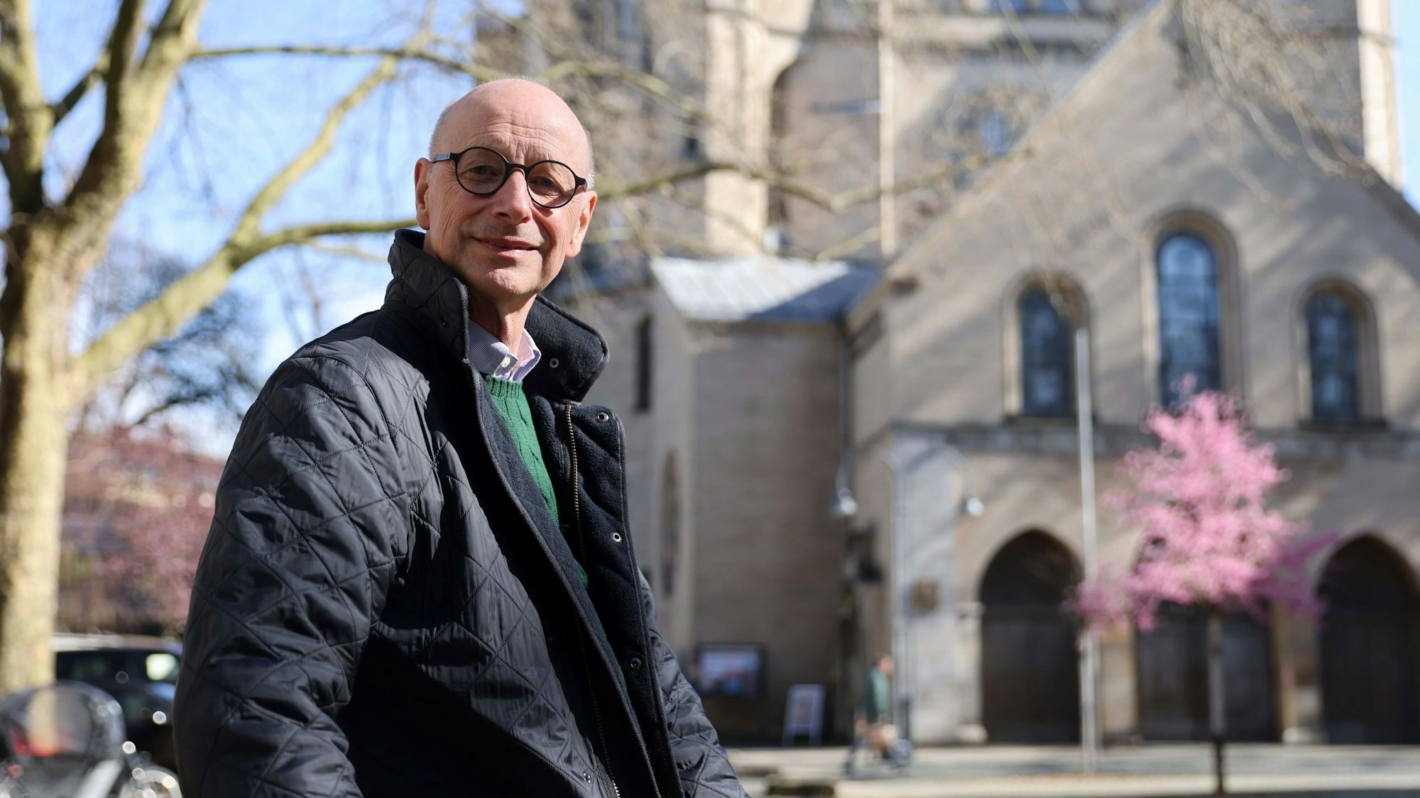 Helmut Loggen sitzt vor einer Kirche.
