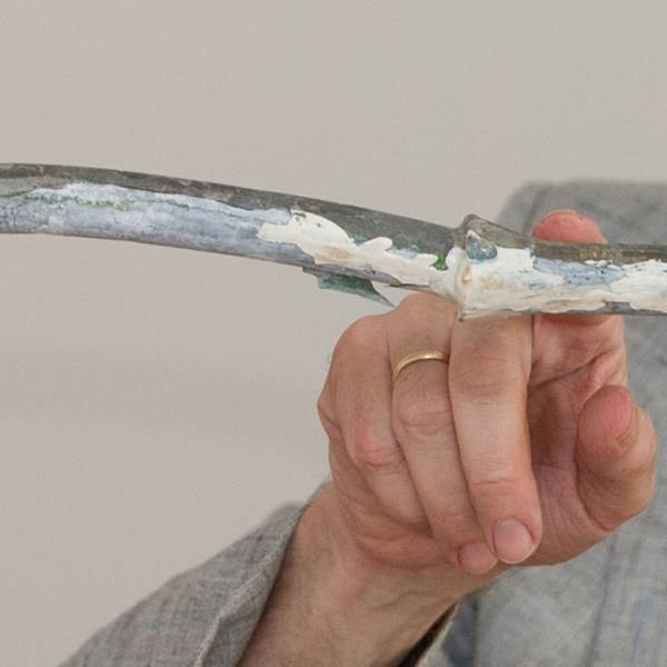 Ein Mann zeigt mit einem Finger auf ein Wasserrohr.