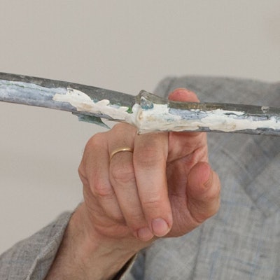 Ein Mann zeigt mit einem Finger auf ein Wasserrohr.