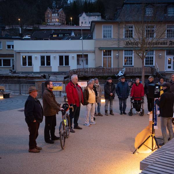 Eine Gruppe von Menschen steht auf dem Nepomuk-Platz in Gemünd.
