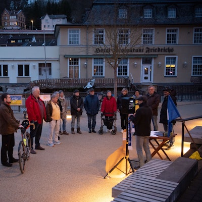 Eine Gruppe von Menschen steht auf dem Nepomuk-Platz in Gemünd.