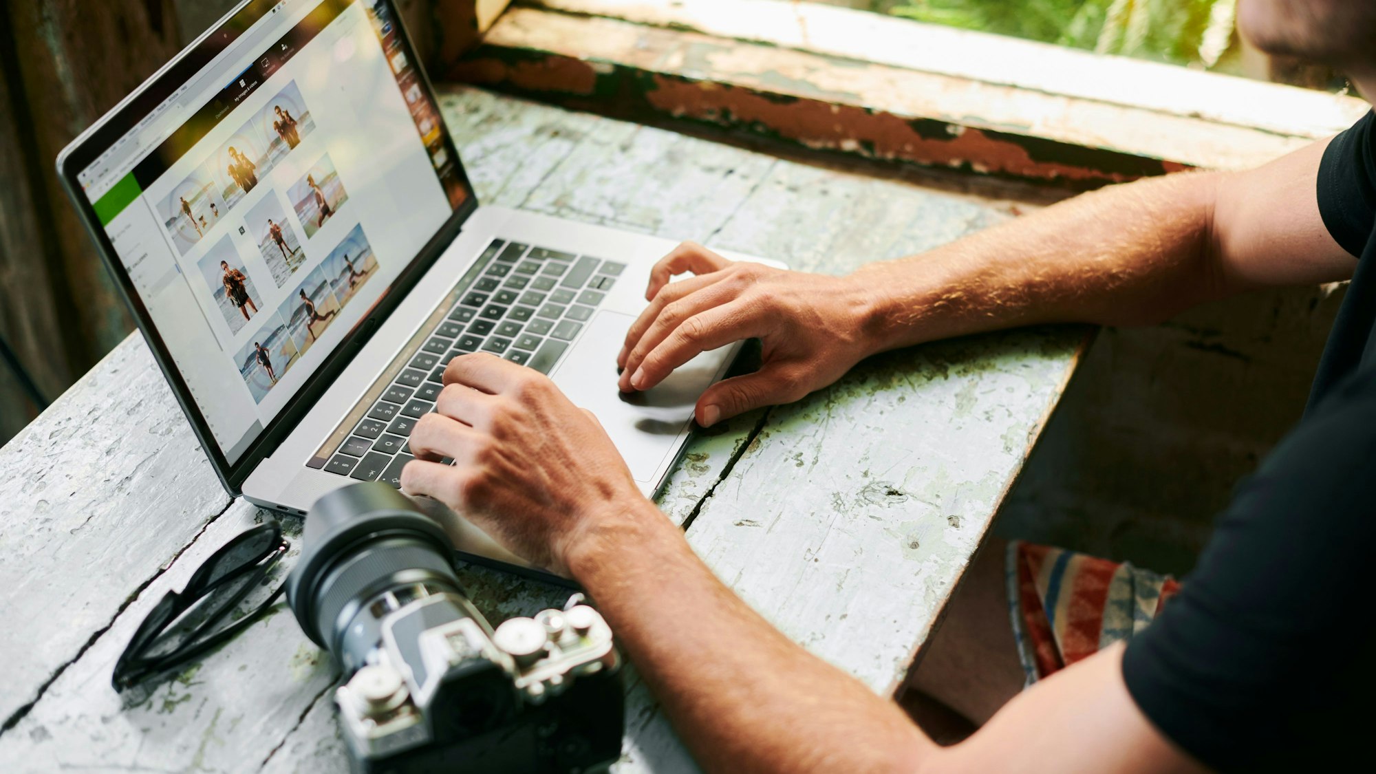 Mann bearbeitet Fotos am Laptop. Symbolbild