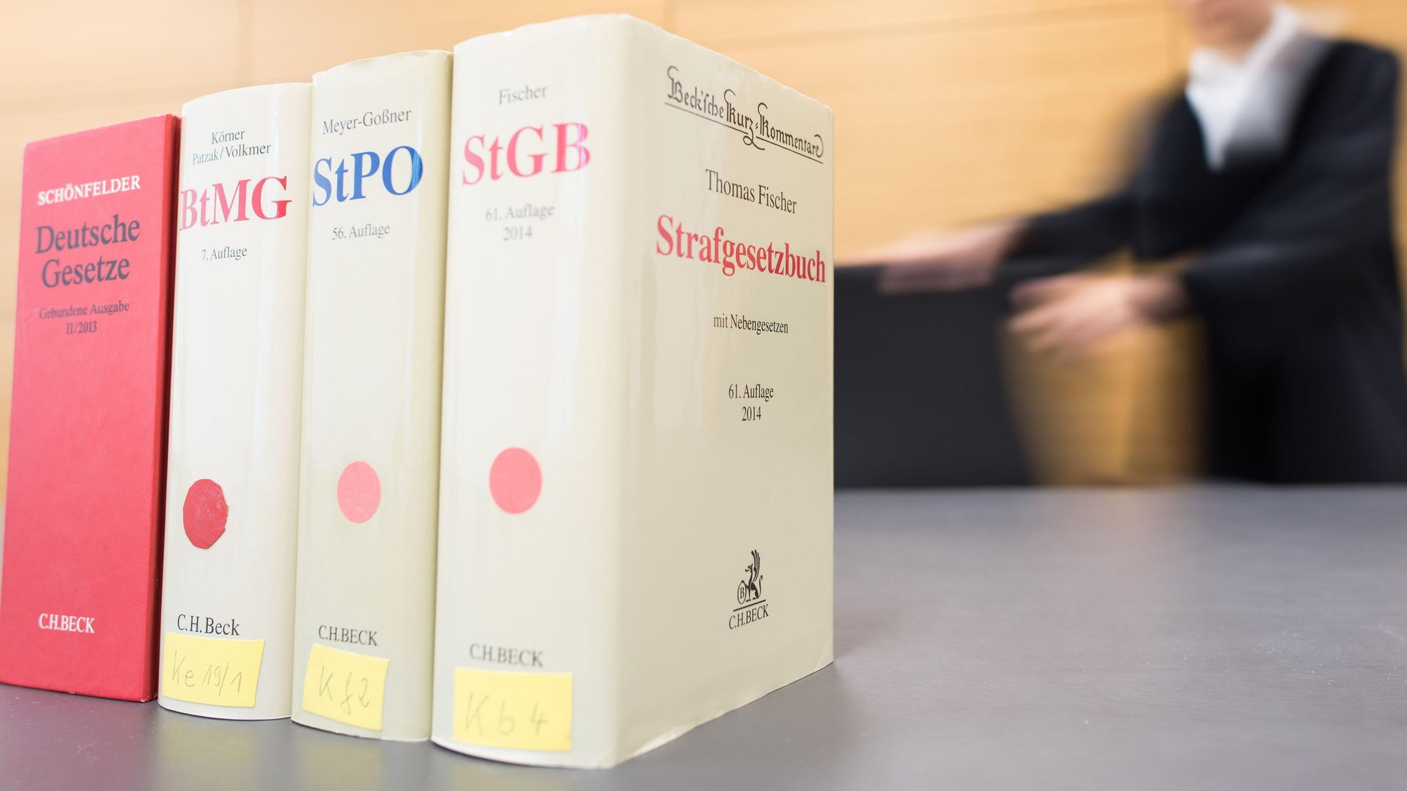 Gesetzbücher stehen auf einem Richtertisch.