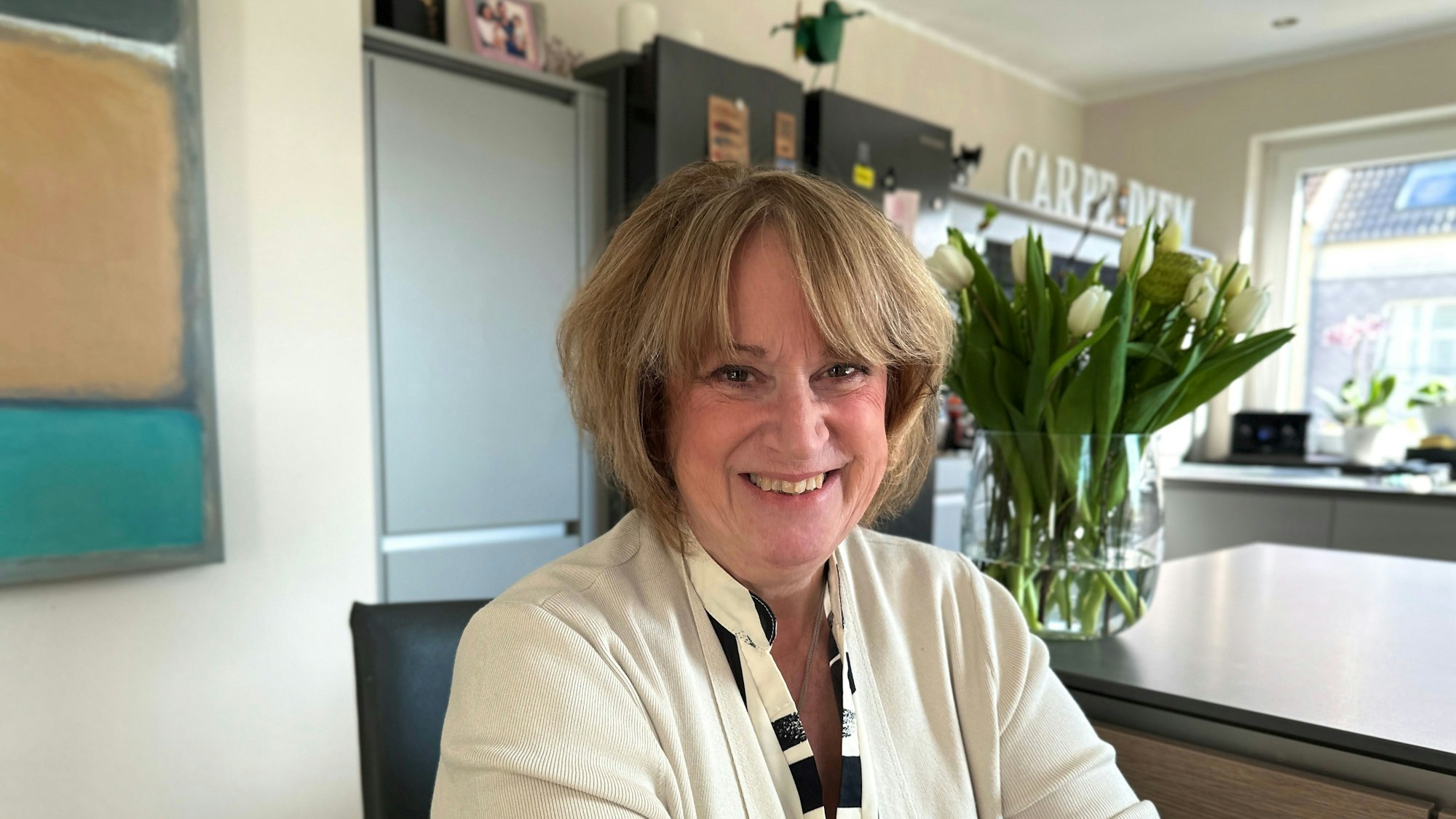 Eine Frau sitzt in einer Küche.