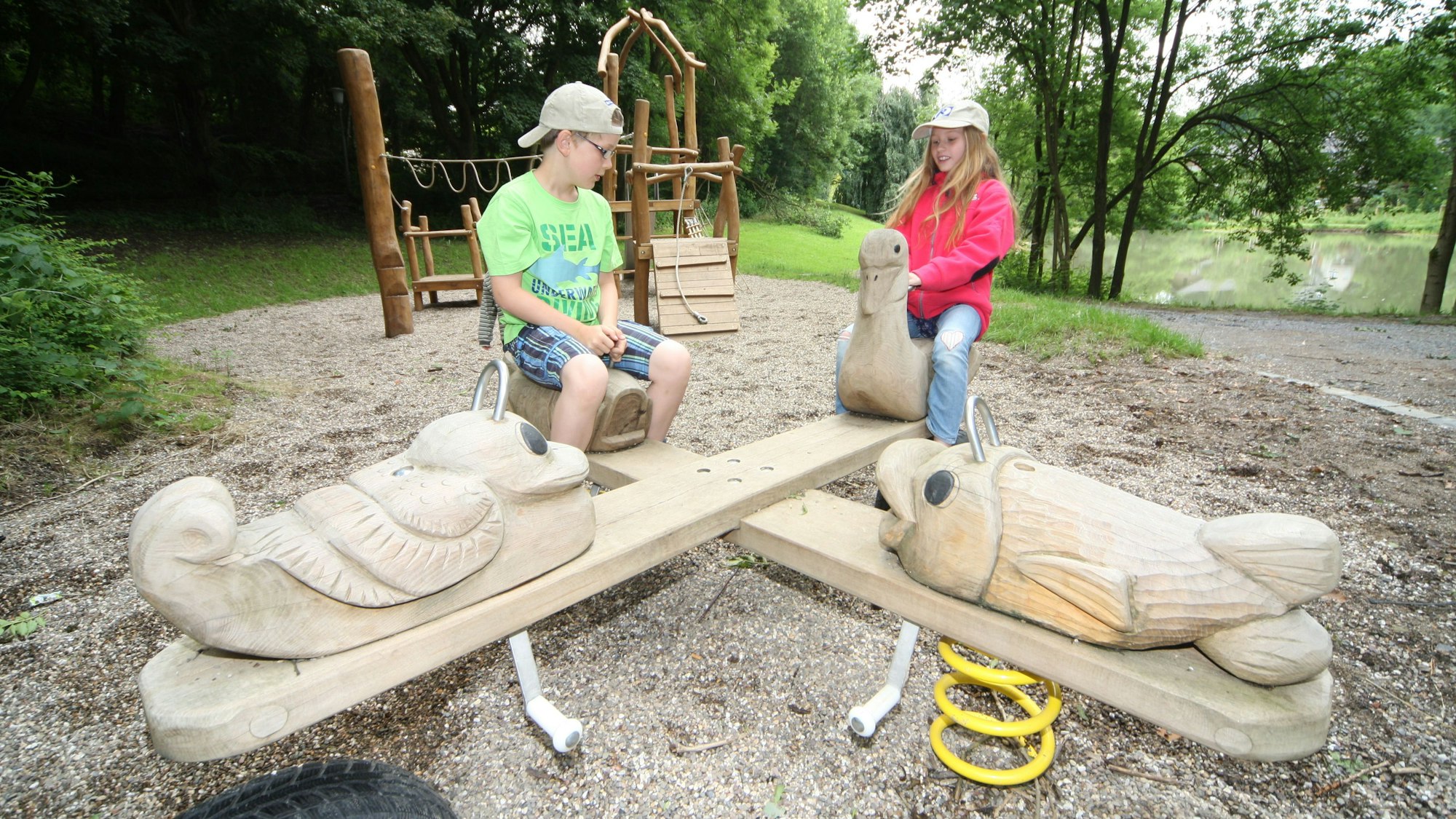 Zwei Kinder sitzen auf einem Spielgerät des Spielplatzes in Herrenstrunden.