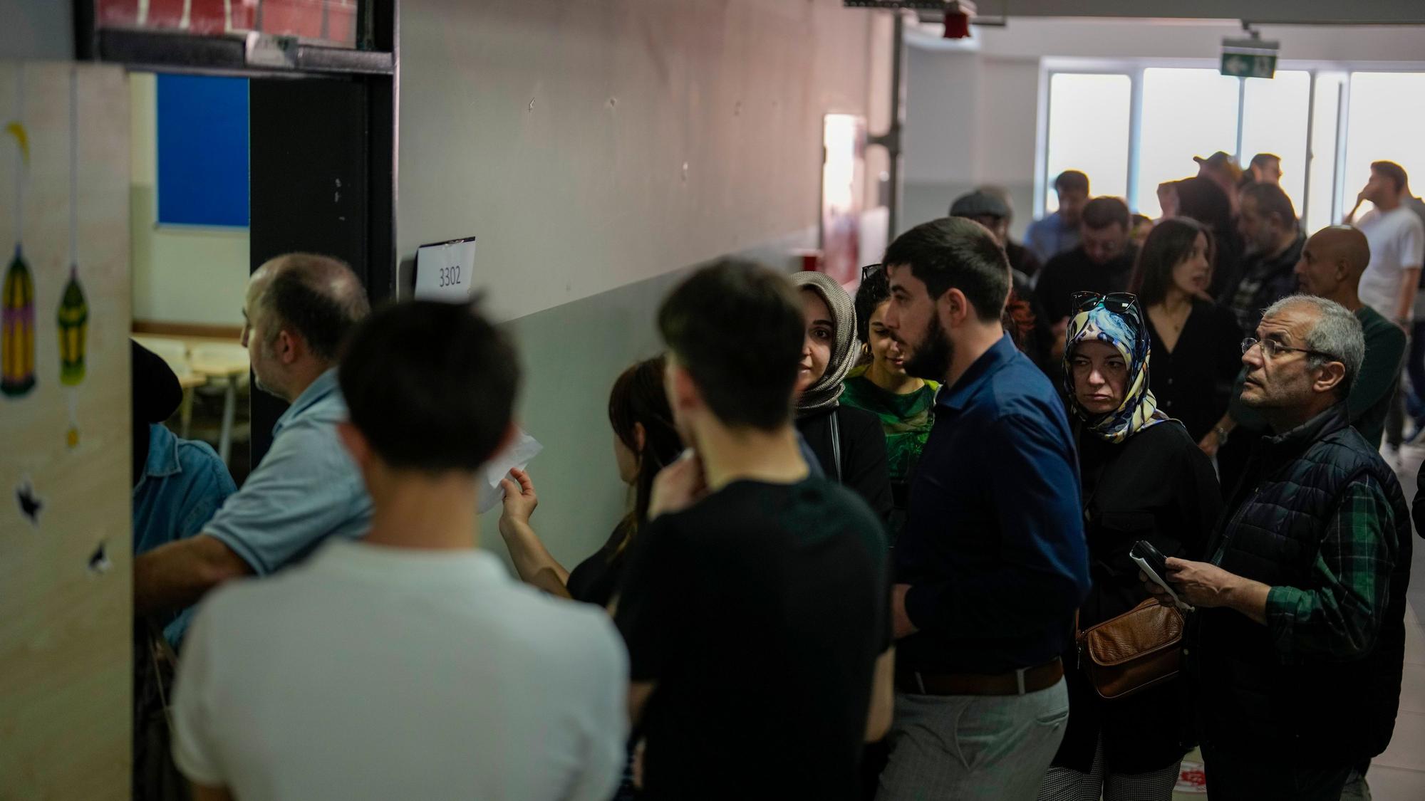 Menschen warten auf ihre Stimmabgabe für die Kommunalwahlen in einem Wahllokal.