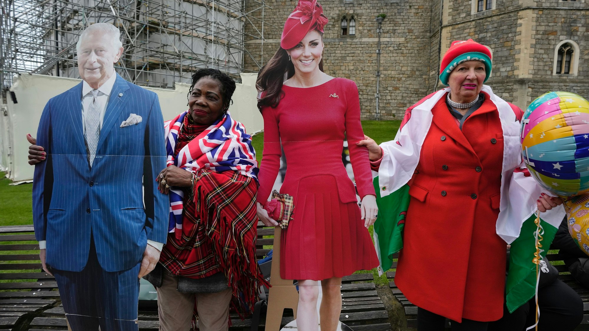 Anhänger des Königspaares halten eine Pappfigur des britischen Königs Charles III. und von Prinzessin Kate vor dem Schloss Windsor, wo die königliche Familie am Ostersonntag an einem Ostergottesdienst teilnimmt.