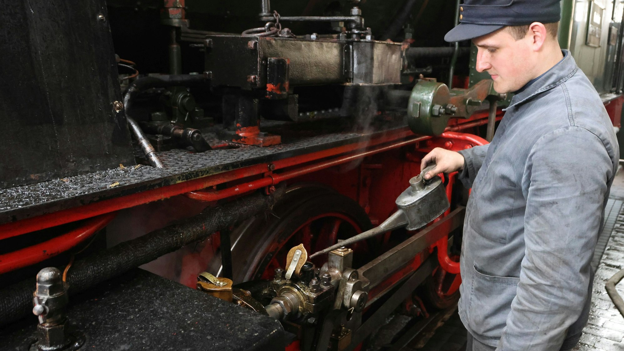 Nachwuchs-Heizer Youssuf Kiani beim Abschmieren der Lok vor der Abfahrt: Eingeheizt haben er und seine Kollegen der alten Lok bereits am vergangenen Freitag.