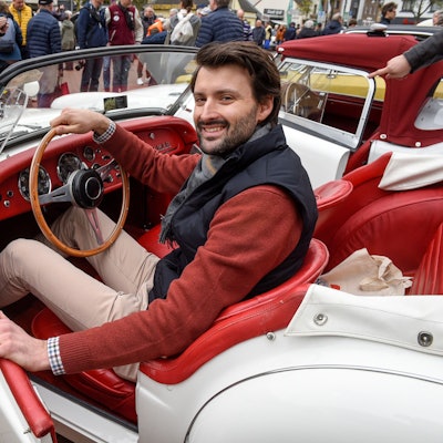 Zu sehen ist Fahrer Dominik Trager in seinen offenen, weißen Triumph TR 3.