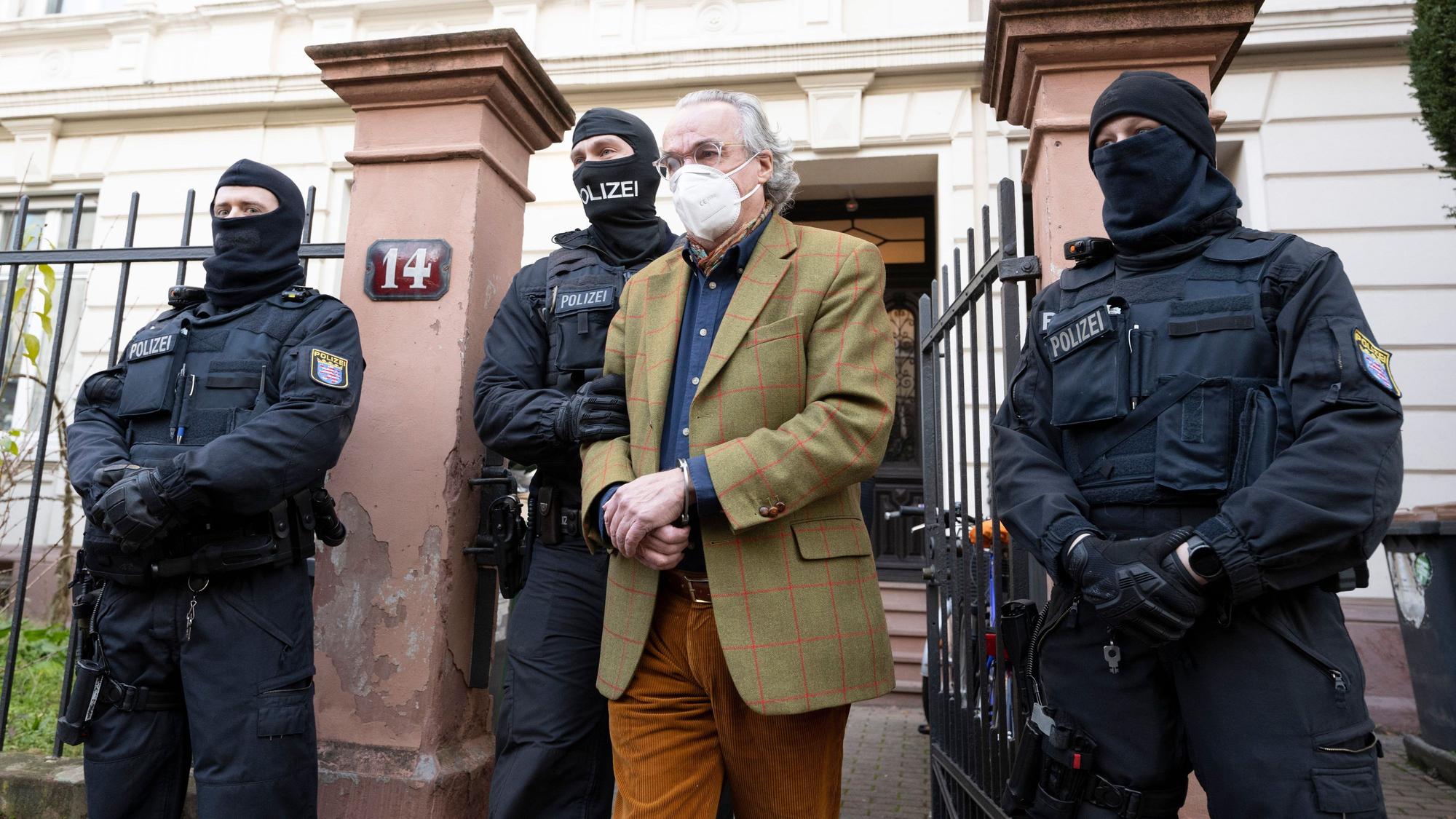 Bei einer Razzia gegen mutmaßliche Reichsbürger führen vermummte Polizisten nach der Durchsuchung eines Hauses Heinrich XIII. Prinz Reuß (2.v.r.) zu einem Polizeifahrzeug.