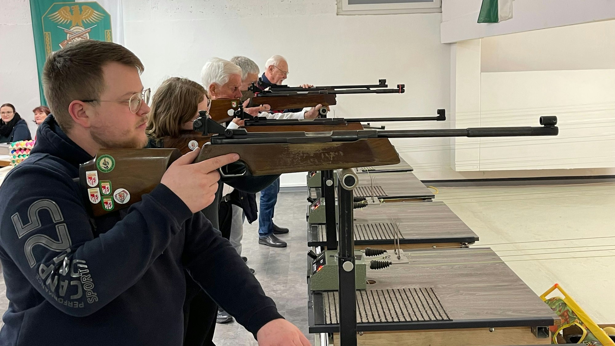 Mehrere Personen zielen mit Schützengewehren auf ein Ziel.