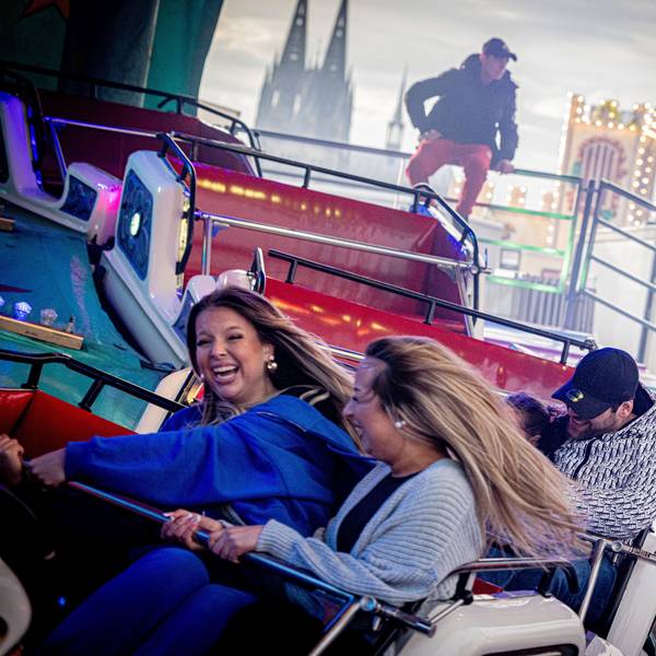 Kirmesbesucher vergnügen sich auf der Osterkirmes in Köln-Deutz.