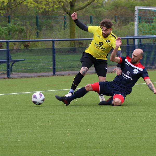 Ein Fußballer stoppt einen Flankenlauf mithilfe eine Grätsche.