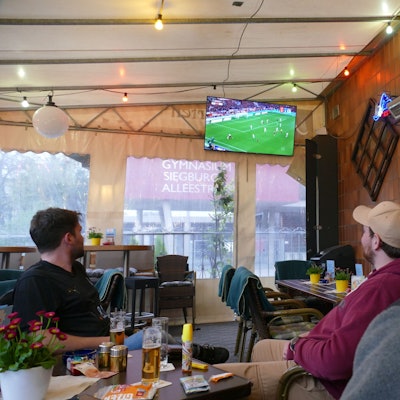 Menschen schauen Fußball in einer Kneipe.