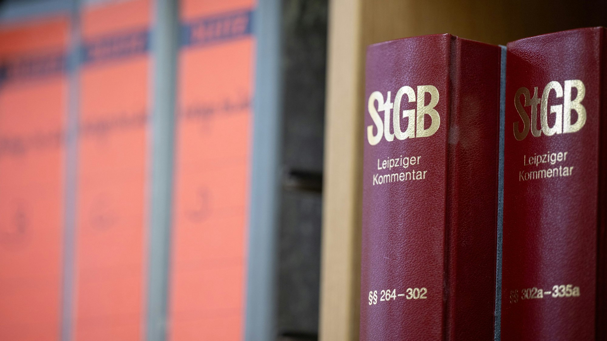 Bücher mit StGB-Gesetzeskommentaren stehen neben Aktenordnern.