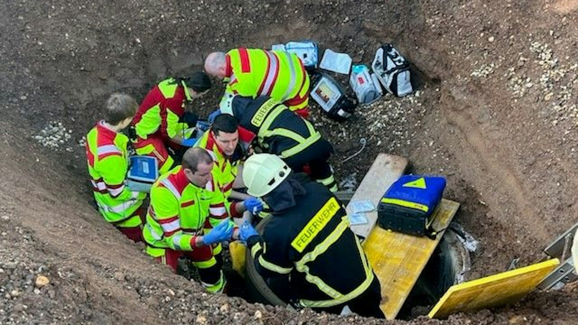 Das Bild zeigt Einsatzkräfte vom Rettungsdienst in einer Baugrube.