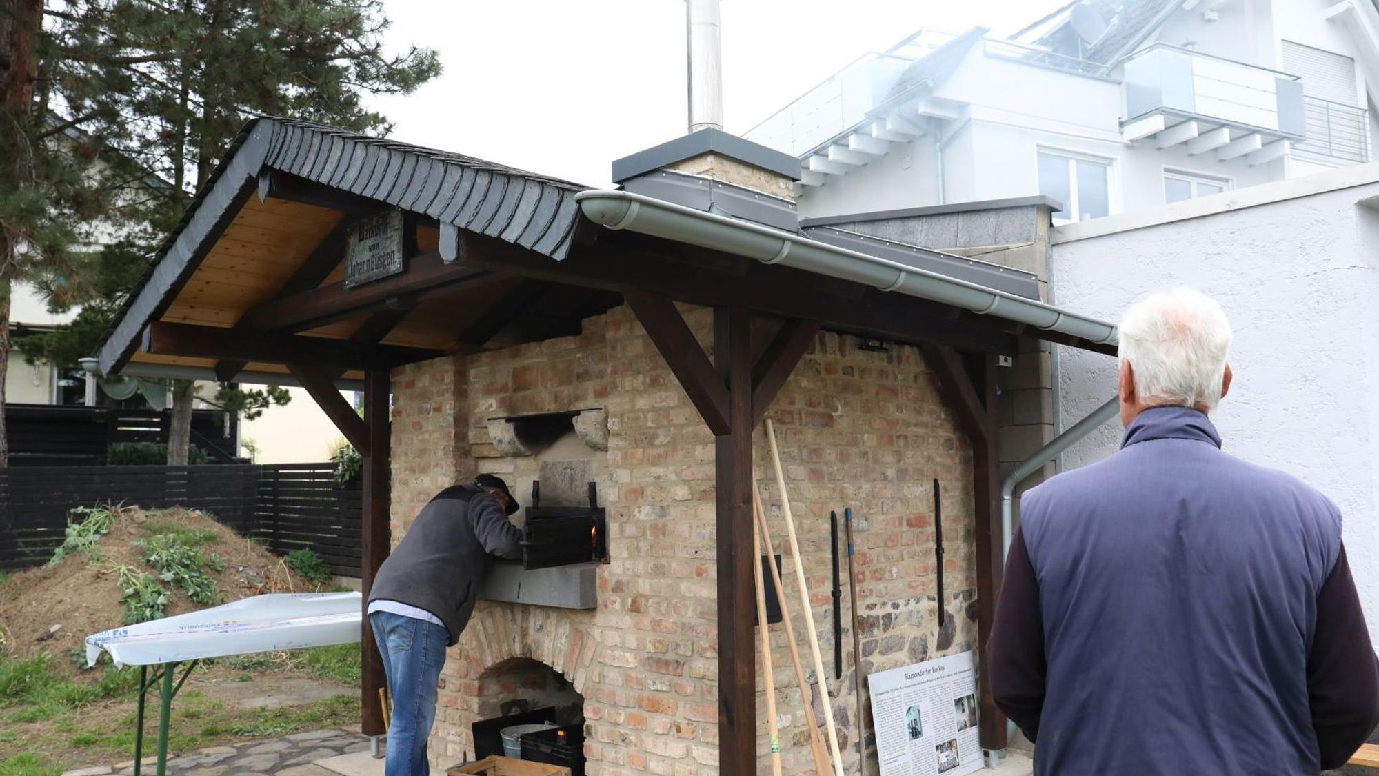 In einem kleinen Backsteinbau mit einem Dach aus Holz und Schiefer ist der Ofen integriert.