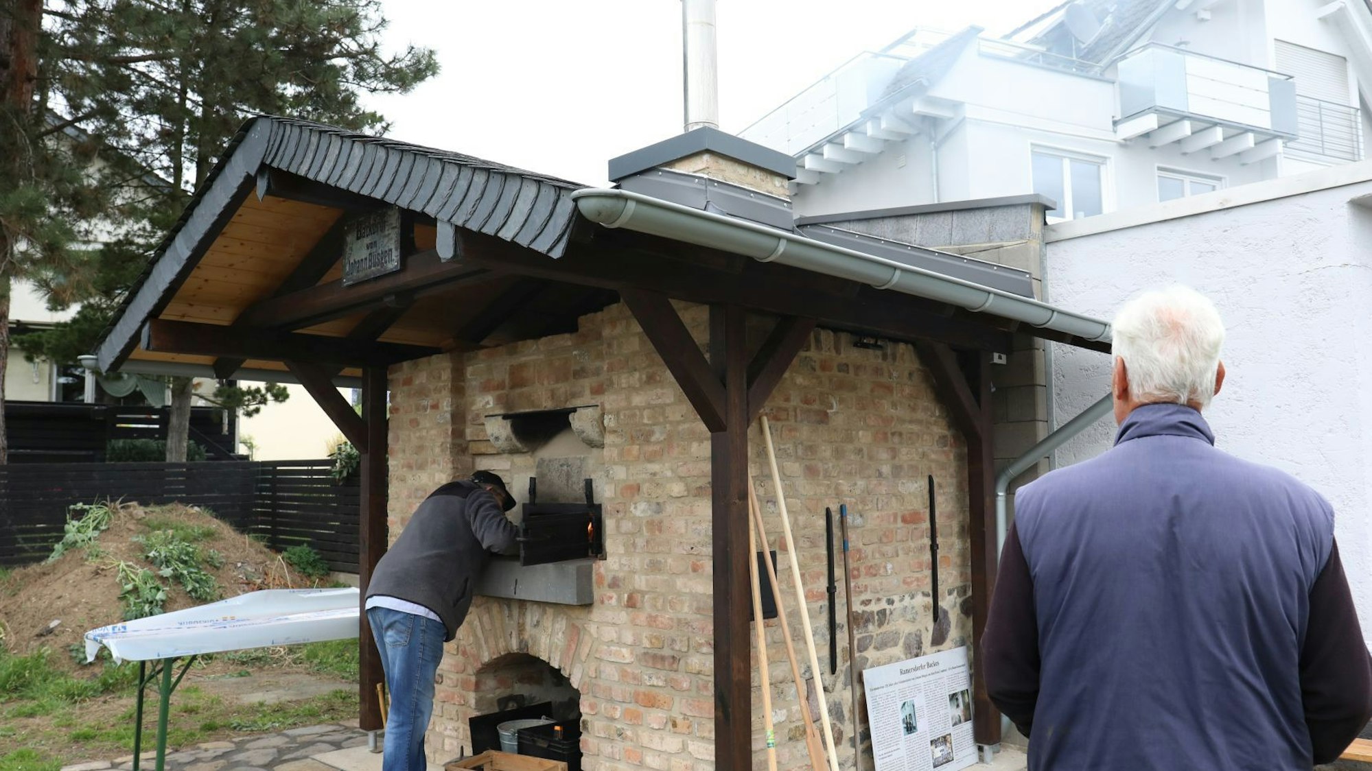 In einem kleinen Backsteinbau mit einem Dach aus Holz und Schiefer ist der Ofen integriert.