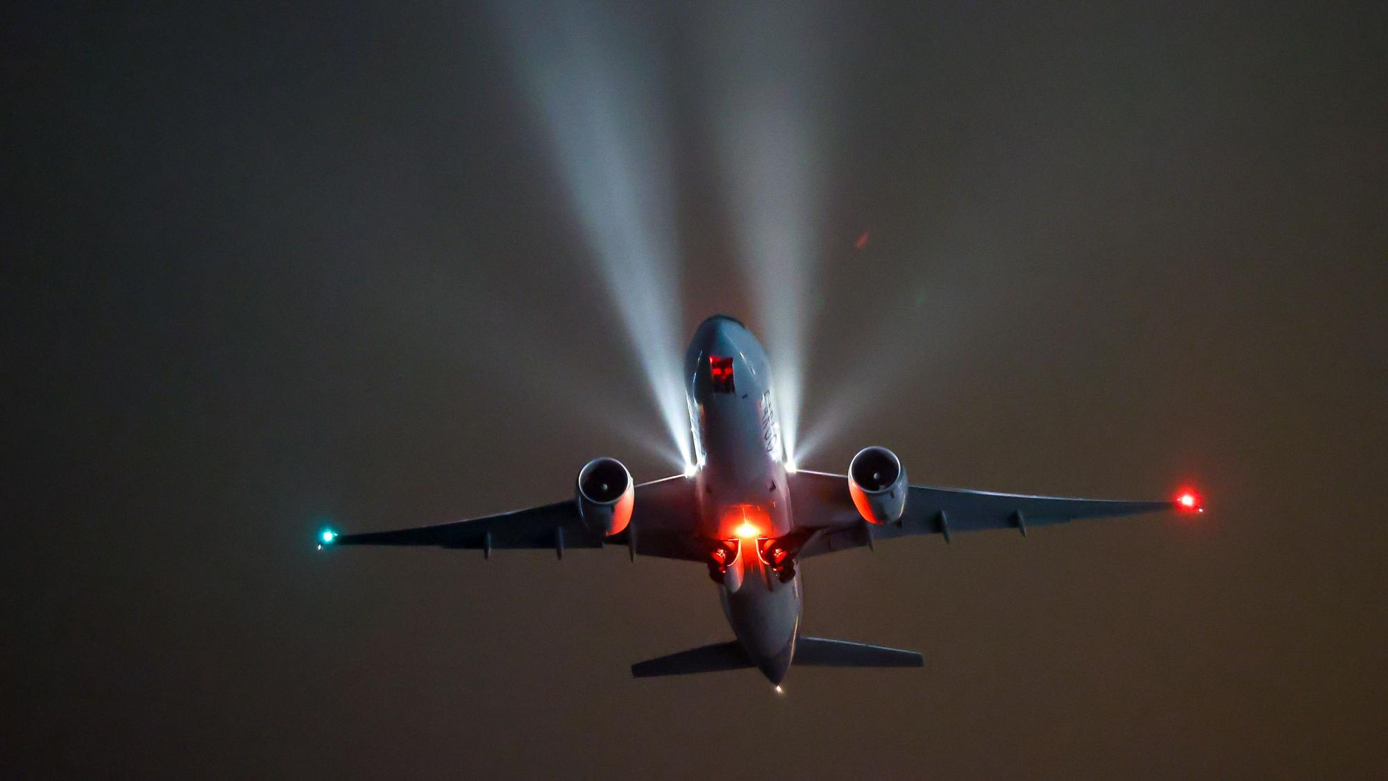 Ein Flugzeug bei Nacht am Himmel.