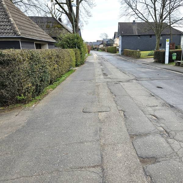 Blick auf die Ortsdurchfahrt mit der mehrfach geflickten Straße.