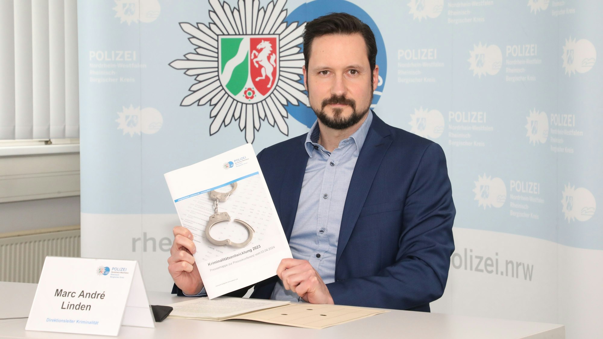 Rhein-Bergs Kripo-Chef Marc André Linden hält die Kriminalitätsstatistik 2023 für Rhein-Berg in den Händen.