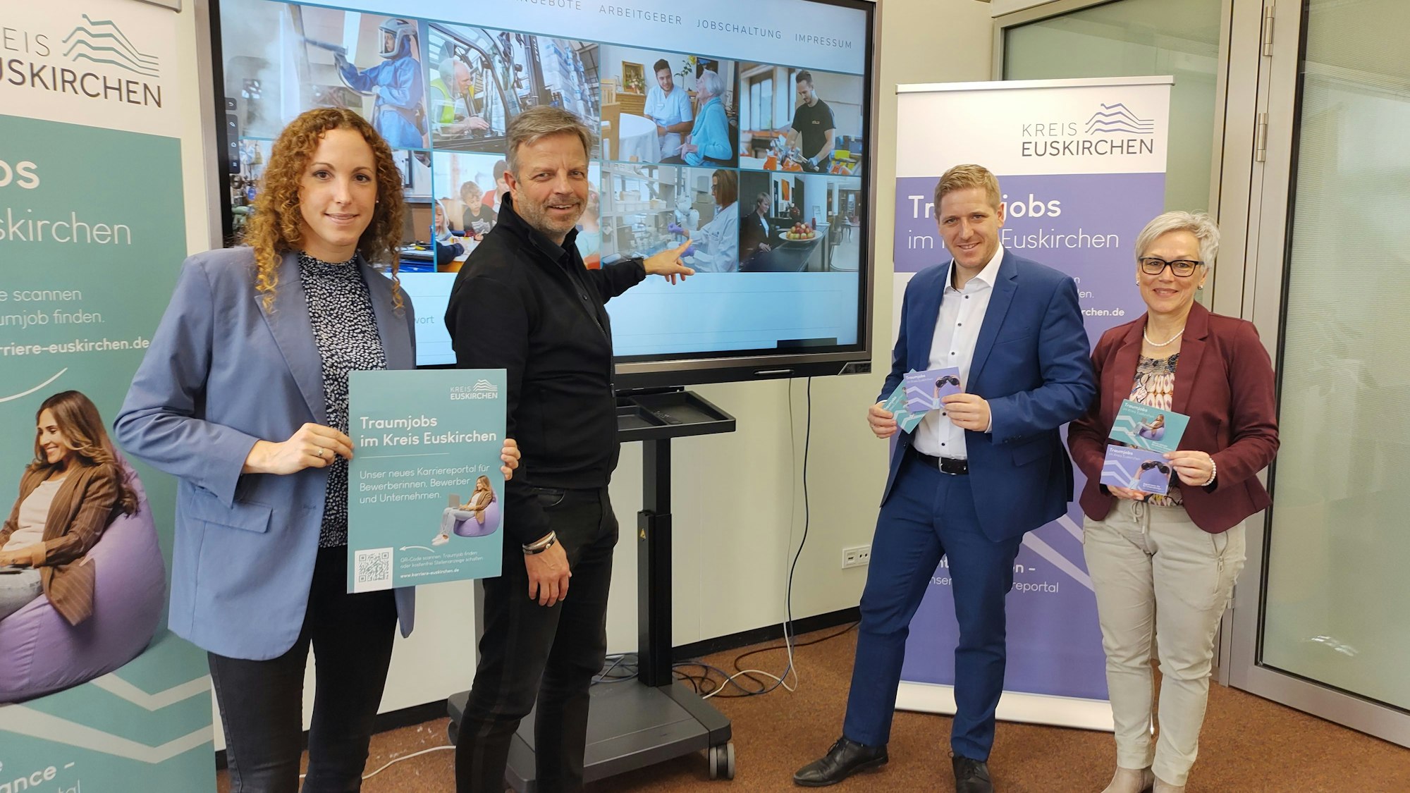 Laura Meyer, Max Samer, Markus Ramers und Iris Poth stehen vor einem großen Bildschirm, an dem Samer das neue Karriereportal erklärte.