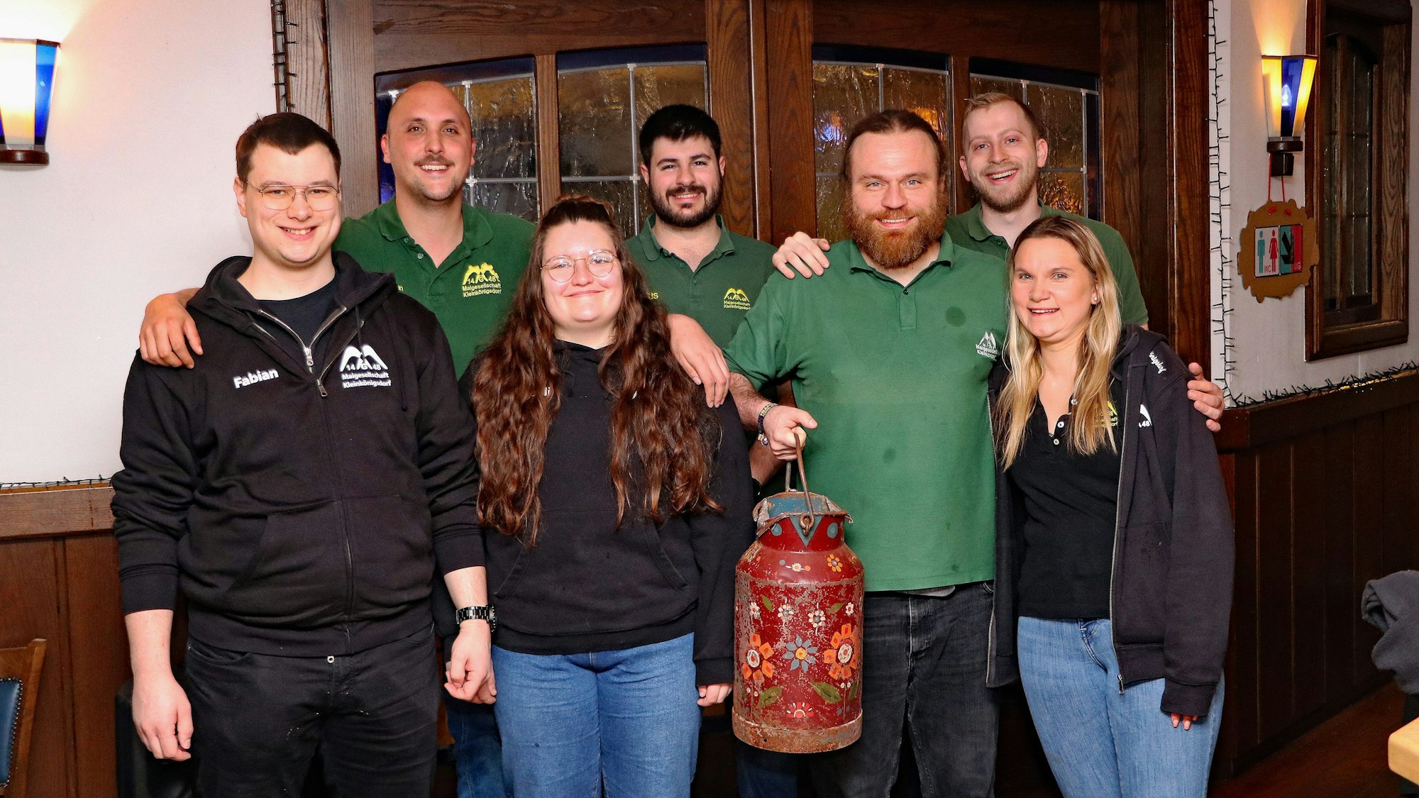 Zwei Frauen und fünf Männer lächeln in die Kamera, die Nacht war lang, sie sind noch müde.