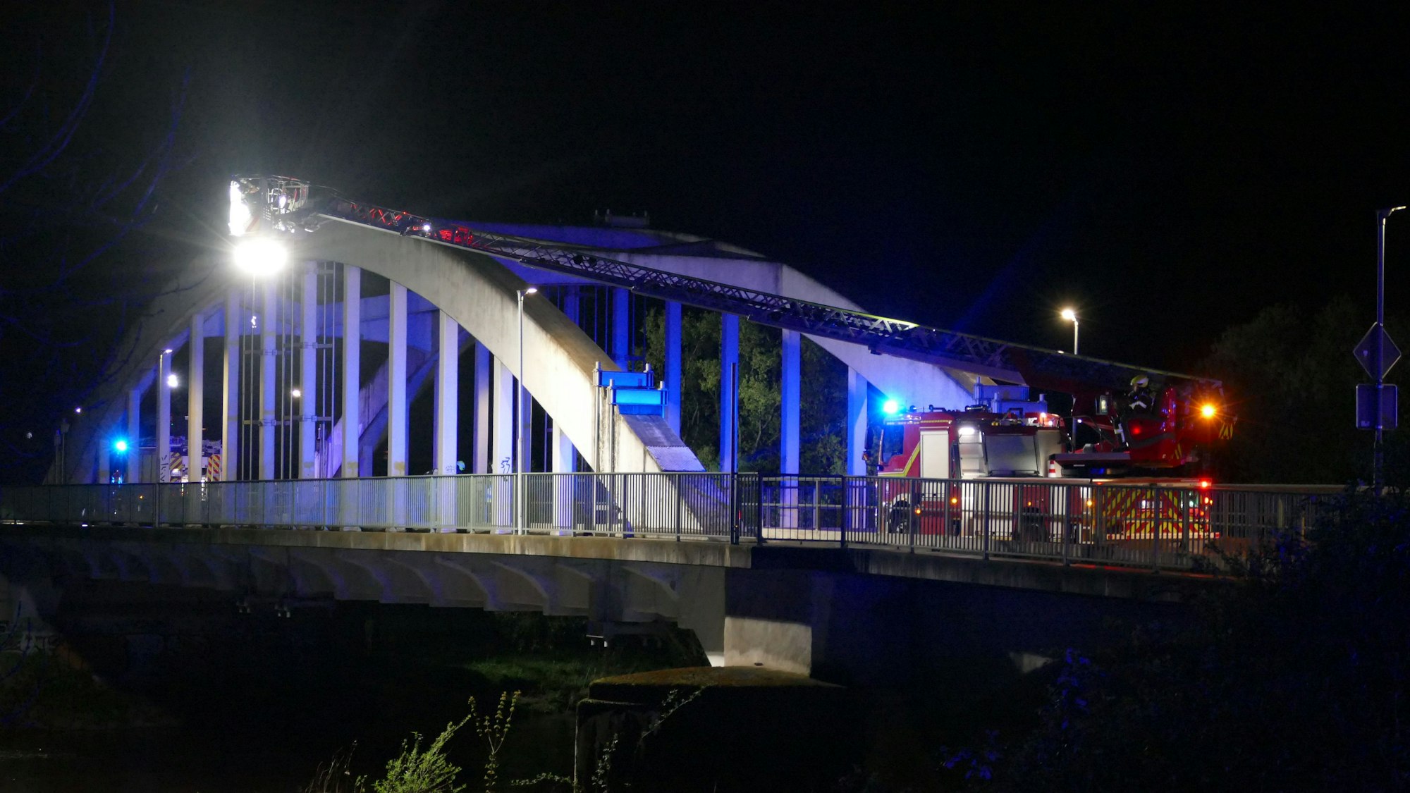 Feuerwehrleute stehen in Meindorf am Siegufer.
