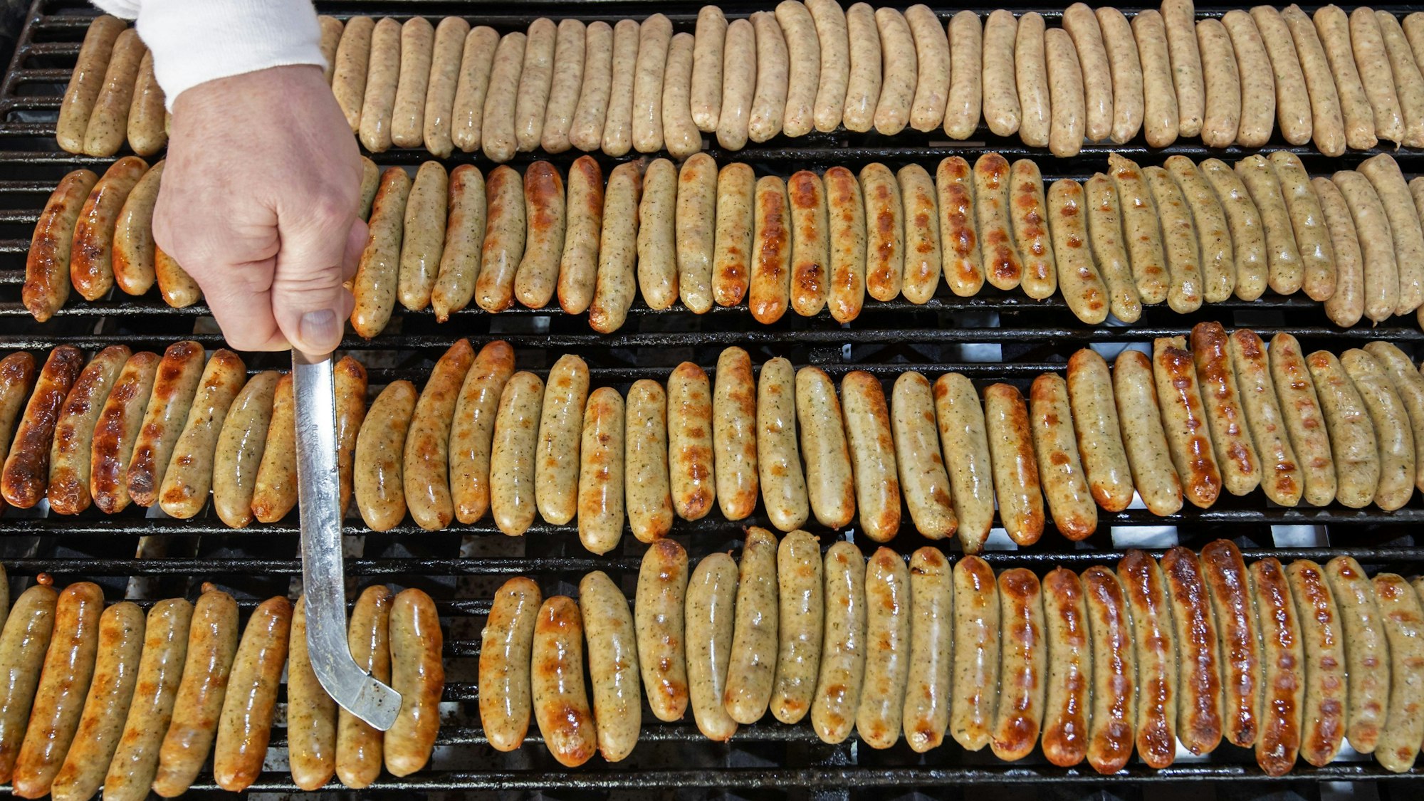 Nürnberger Rostbratwürste liegen an einem Stand auf dem Nürnberger Christkindlesmarkt auf einem Grill.