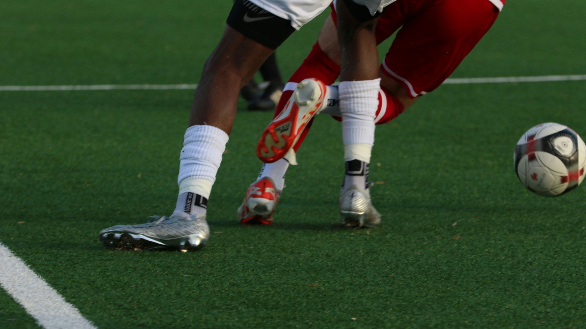 Das Bild zeigt zwei Fußballer im Zweikampf.