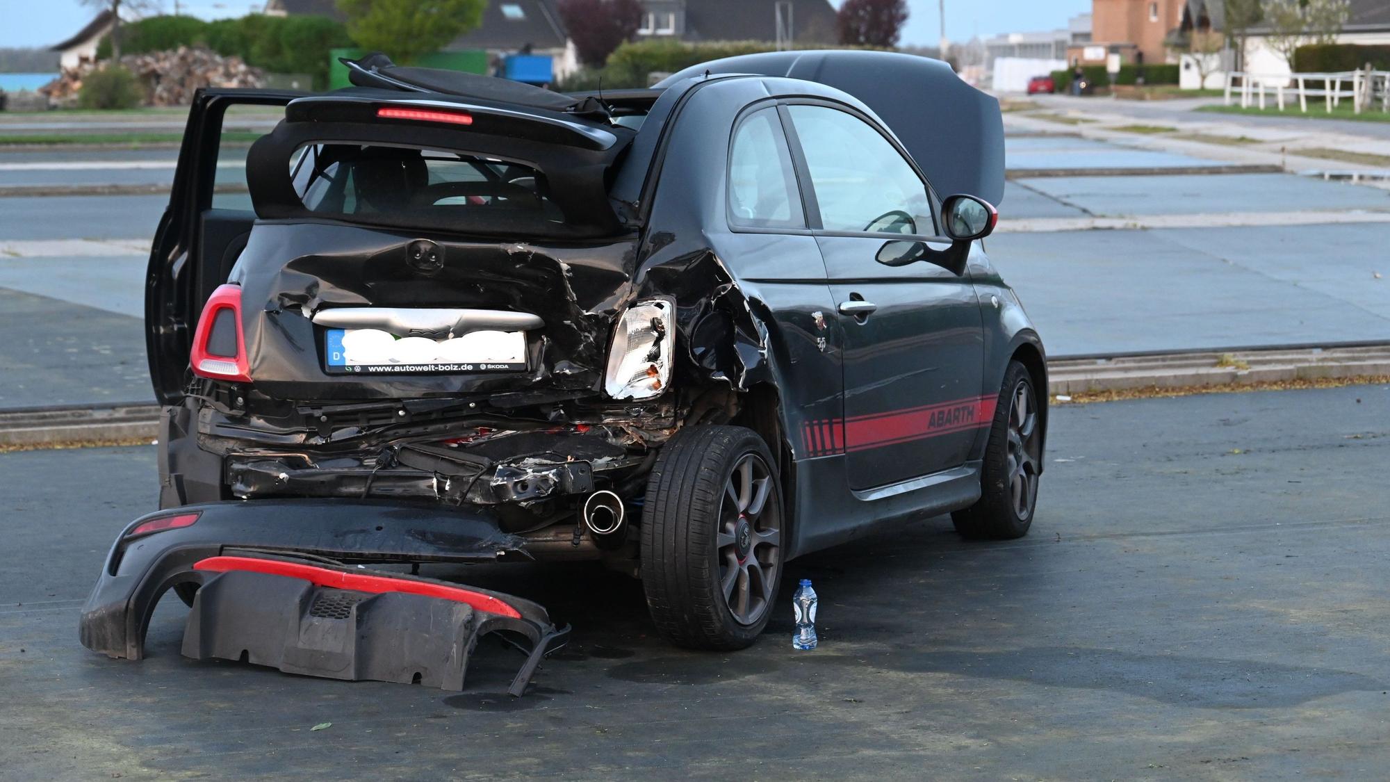 Ein am Heck stark beschädigtes Auto steht auf einer flachen Fläche.