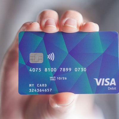 Ein Mann hält eine Hamburger Bezahlkarte für Asylsuchende in der Hand.